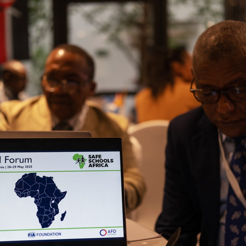 Ordinateur portable ouvert sur une table de conférence, affichant le logo de Safe Schools Africa et une carte de l’Afrique.