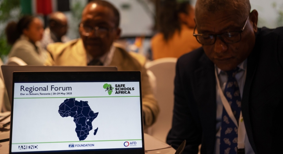 Ordinateur portable ouvert sur une table de conférence, affichant le logo de Safe Schools Africa et une carte de l’Afrique.
